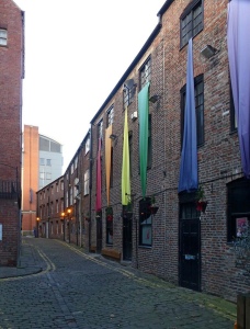 A row of red brick buildings in a narrow alley